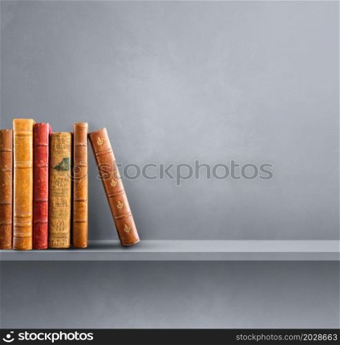 Row of old books on grey shelf. Square scene background. Row of old books on grey shelf. Square background
