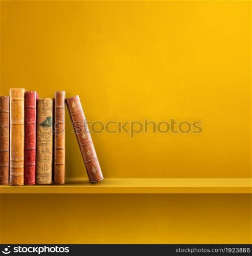 Row of old books on yellow shelf. Square scene background. Row of old books on yellow shelf. Square background