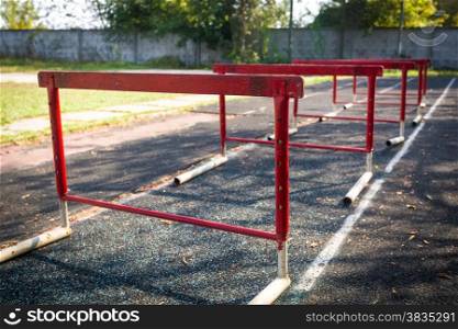 Row of old red hurdles for a hurdle race on abandoned stadium
