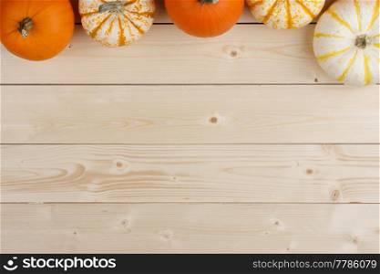 Row of orange pumpkins on wooden background, Halloween concept. Pumpkins on wooden background