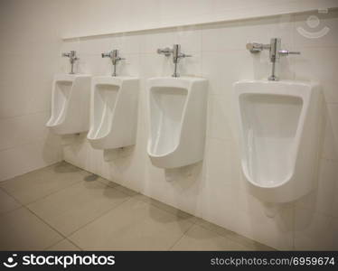 Row of outdoor urinals men public toilet room