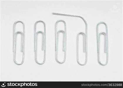 Row of paper clips with one bent