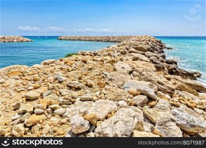 Row of rocks and stones as weir in greek ocean