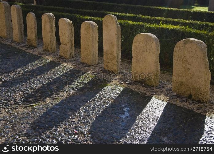 row of roman gravestones with long shadows