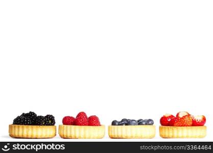 row of tartlets with wild berries. row of tartlets with wild berries on white background