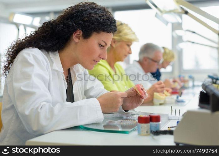 row of technicians working on prostheitc teeth