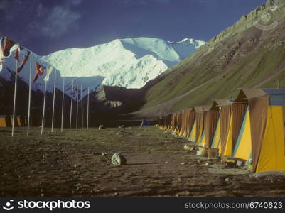 Row of tents & flags, Pik Lenin in background, International Mountaineering Camp, Achik Tash , Pamir mountain range, Himalayas, Central Asia, former USSR, now border of Tajikistan and Kyrgyzstan, near Afghanistan