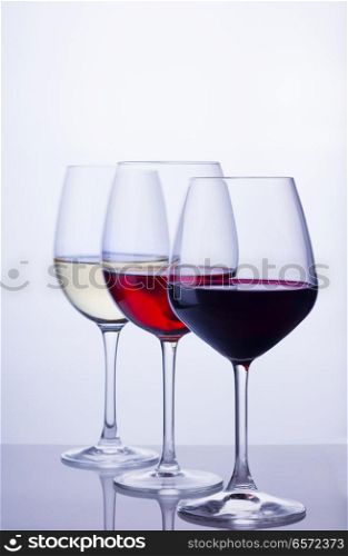 Row of three wine glasses with red, white and rose wine. Set of glasses with wine