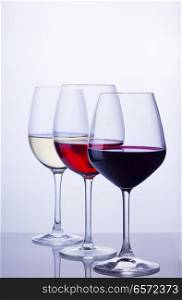 Row of three wine glasses with red, white and rose wine. Set of glasses with wine