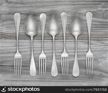 Row of vintage forks and spoons on old wooden boards