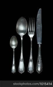Row of vintage knife, fork and spoons are isolated on black background