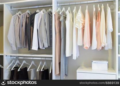 row of white dress and shirts hanging in white wardrobe