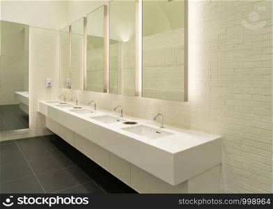 Row of white modern marble ceramic wash basin in public toilet, restroom in restaurant or hotel or shopping mall, interior decoration design