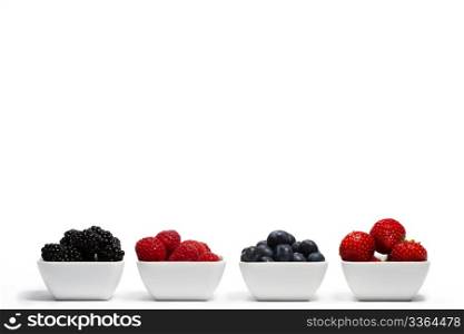 row of wild berries in bowls. row of wild berries in bowls on white background