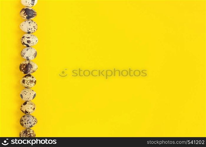 Row on left edge quail eggs on yellow paper background. Easter concept. Template Creative Flat lay Top view Copy space lettering, text or your design.. Row on left edge quail eggs on yellow paper background. Easter concept. Template Creative Flat lay Top view Copy space lettering, text or your design