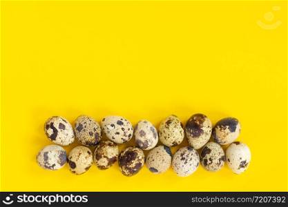 Row quail eggs on yellow paper background. Top view Copy space.. Row quail eggs on yellow paper background. Top view Copy space