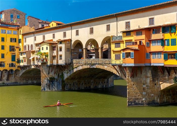 Rower canoe before the bridge Ponte Vecchio across River Arno in the sunny summer day, Florence, Tuscany, Italy