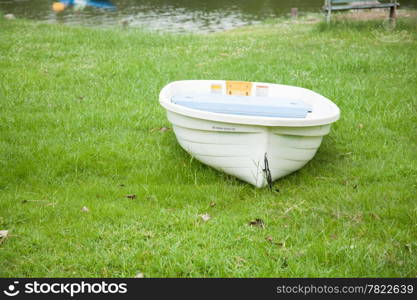 Rowing boat in the lawn. Within the park. Behind the pool.