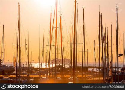 rows of boats at pier in the evening against sunset skies (sunset dusk lighting)