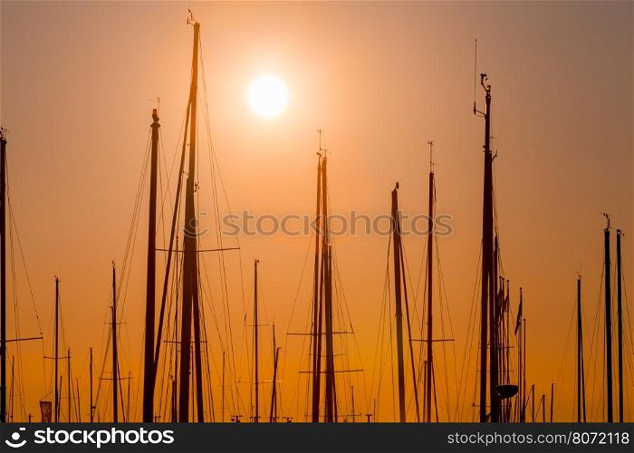 rows of boats at pier in the evening against sunset skies (sunset dusk lighting)