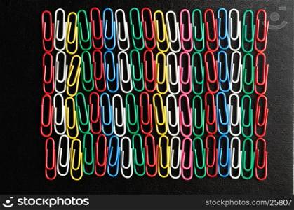 Rows of colorful paper clips on a black background