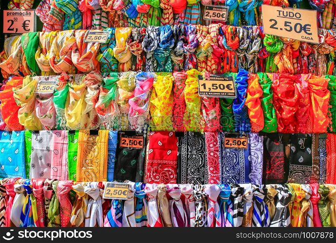 Rows of colorful scarves hanging for sale at market in Madeira