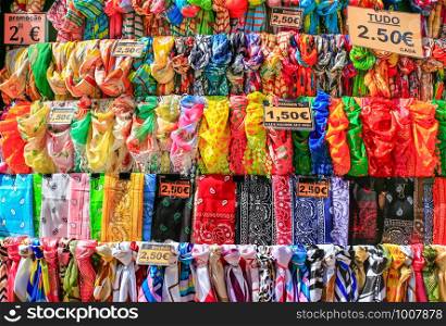 Rows of colorful scarves hanging for sale at market in Madeira