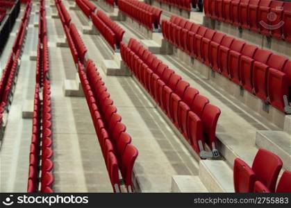 Rows of empty red seats in a football stadium