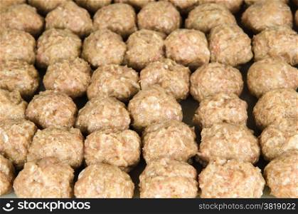 Rows of home made meatballs ready to fry