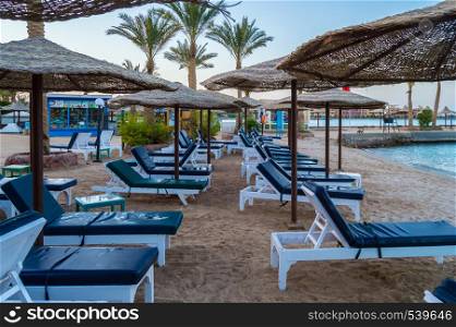 Rows of sunbeds and umbrellas on a beach in the city of Hurghada in Egypt. Rows of sunbeds and umbrellas