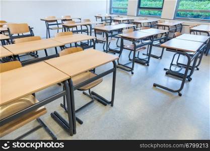 Rows of tables and chairs in classroom on high school