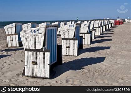 rows of wicker roofed beach chairs standing at the beach in Warnemuende