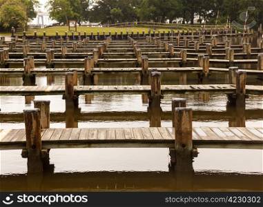 Rows or empty boat docks on a cloudy rainy day with no boats