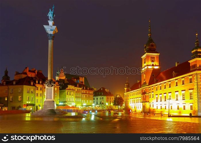 Royal Castle and Sigismund Column at Castle Square illuminated in Warsaw Old town at rainy night, Poland.