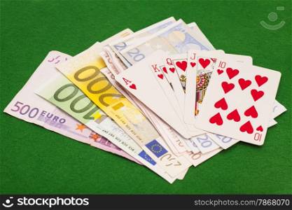 Royal flush hearts and euro money on green felt