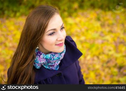 Rub a beautiful girl on the blurry background of autumn leaves