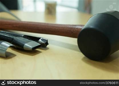 Rubber hammer and chisel Placed on a wooden table What types of Different patterns of use.