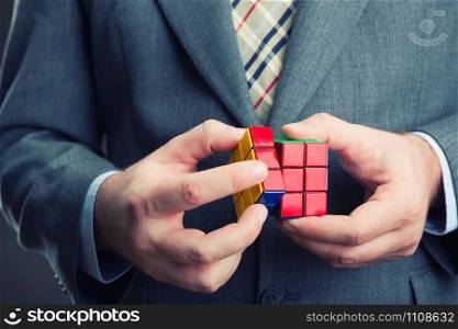 Rubik cube in hands of man