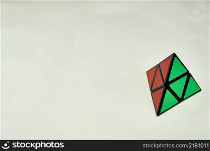 rubik&rsquo;s cube pyramorphix, solved on white background with copy space.. rubik&rsquo;s cube pyramorphix, solved on white background with copy space