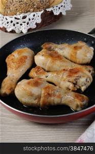 Ruddy fried chicken drumsticks in a pan