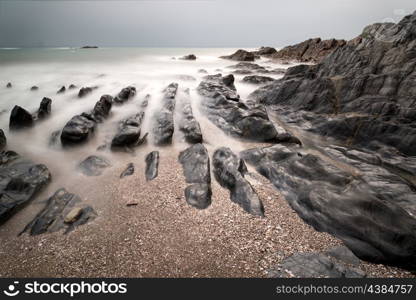 Rugged long exposure landscape seascape of rocky coastline