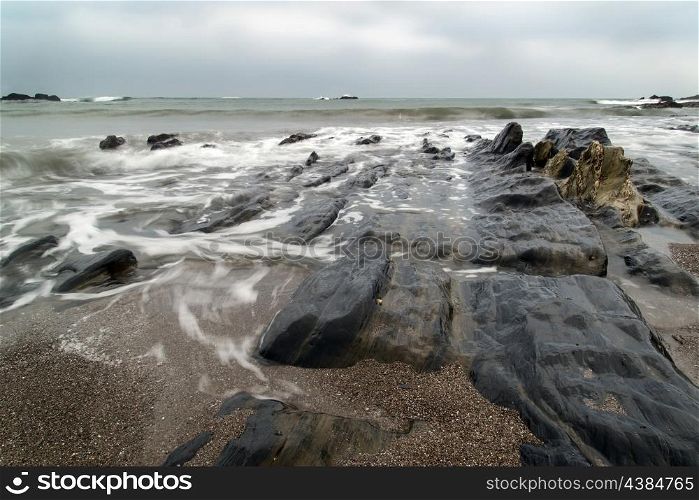 Rugged long exposure landscape seascape of rocky coastline