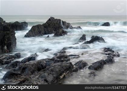Rugged long exposure landscape seascape of rocky coastline