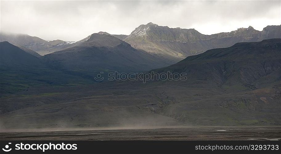 Rugged misty mountains rising from the ocean coastline