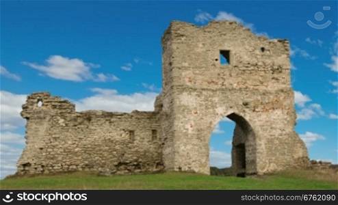 Ruined gates of cossack castle with blue sky and clouds