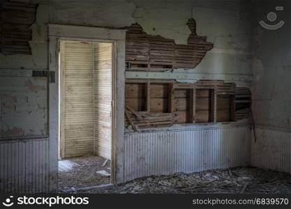 ruined interior and entry of an old abandoned school house in rural Nebraska