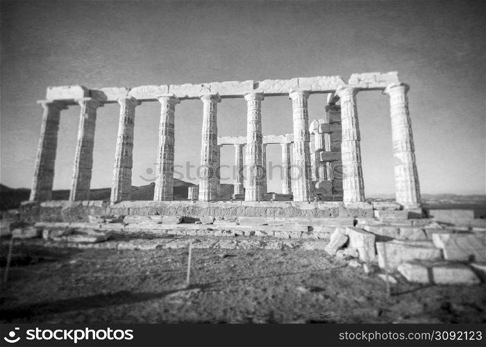 Ruins of an ancient temple of Poseidon at Greece Cape Sounio. Poseidon is the Greek god of the sea. Shot of temple ruins on sunset. Tourist landmark of Attica, Sounion, Greece.. Greece Cape Sounio. Ruins of an ancient temple of Poseidon, the Greek god of the sea, on sunset.