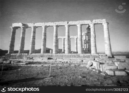 Ruins of an ancient temple of Poseidon at Greece Cape Sounio. Poseidon is the Greek god of the sea. Shot of temple ruins on sunset. Tourist landmark of Attica, Sounion, Greece.. Greece Cape Sounio. Ruins of an ancient temple of Poseidon, the Greek god of the sea, on sunset.