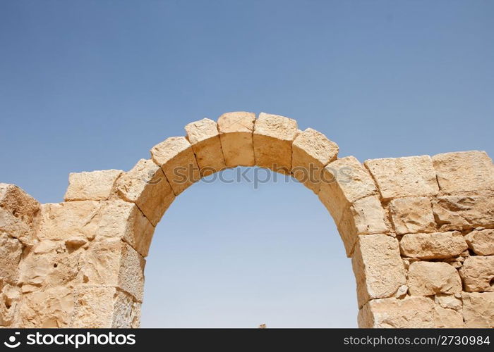 Ruins of ancient stone arch on sky background