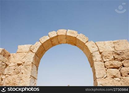 Ruins of ancient stone arch on sky background